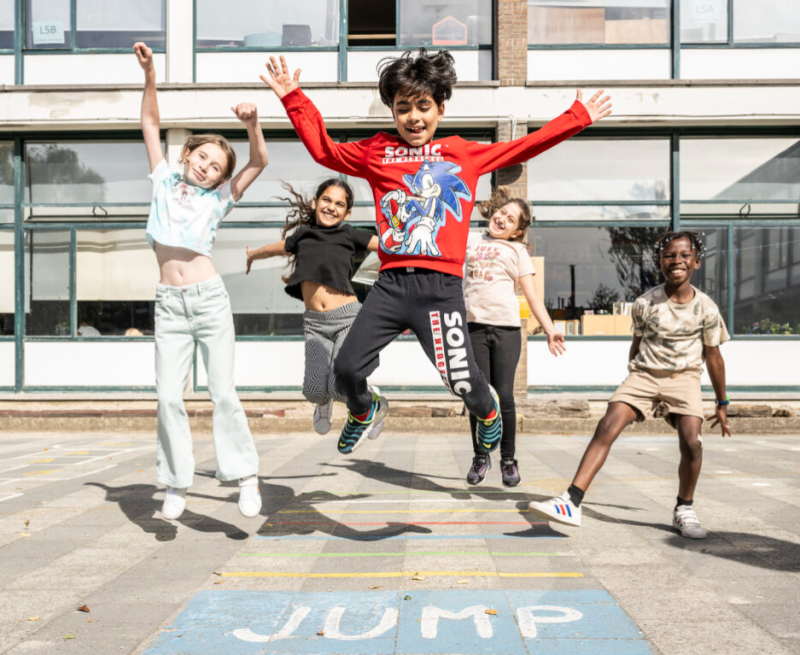 Leerlingen springen op de speelplaats van stedelijke basisschool De Kangoeroe